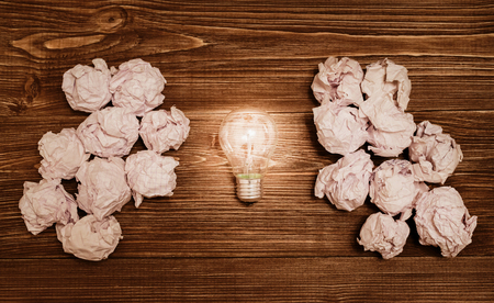 Great idea concept with crumpled paper and light bulb in the center on wooden tableの写真素材