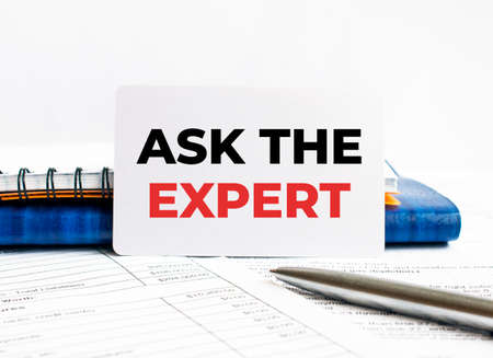 Business card with text Ask the Expert lying on blue notebook, conceptの写真素材