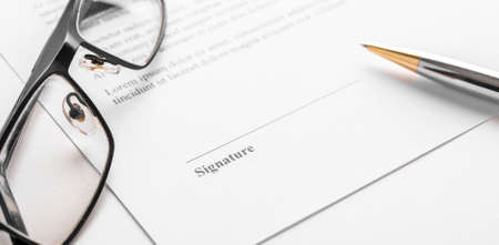 Signaure for contract with pen and glasses.の写真素材