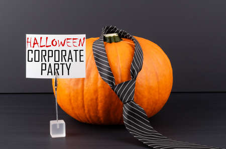Word Corporate Party written on a paper with a halloween pumpkin on background.の写真素材