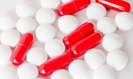 Image of red and white pills on white background. Medicine concept