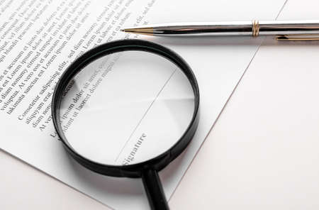 Signaure line in contract with pen and magnifying glass.の写真素材