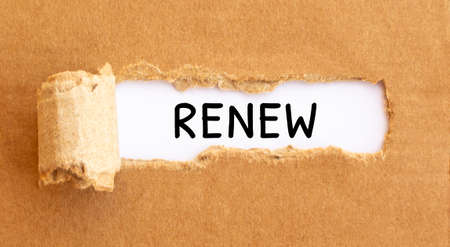 Text Renew appearing behind torn brown paper.の写真素材
