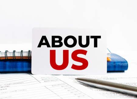 Business card with text About us lying on blue notebook.の写真素材