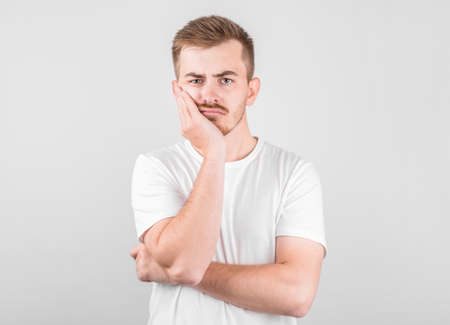Young man with an expression of discontent on his face.