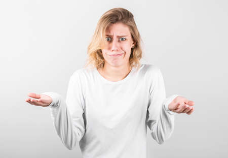 Young beautiful blonde woman wearing casual shirt over white background clueless and confused with open arms, no idea conceptの写真素材