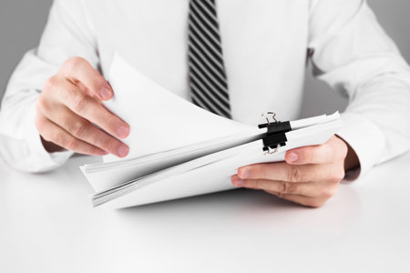 Businessman working in stacks of paper files for searching information on work desk home office,...