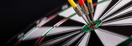 Red and yellow darts arrows on center of dartboard. Concept o business target, success and win.の写真素材