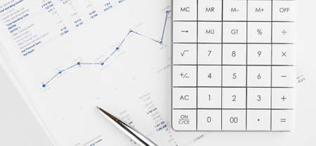 Financial charts and a calculator on the accountant's desk. Calculating profits, taxes, and paying employees salaries.の写真素材