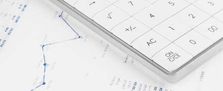 Financial charts and a calculator on the accountant's desk. Calculating profits, taxes, and paying employees salaries.の写真素材