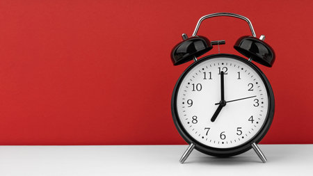Black alarm clock on a red backgroundの写真素材