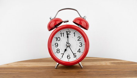 Red alarm clock on gray wall backgroundの写真素材
