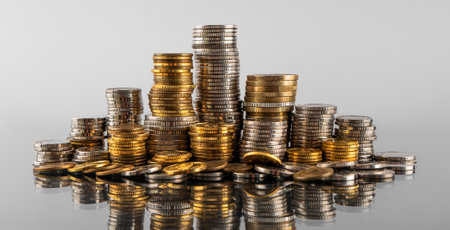 Stacks of coins in reflection on a gray backgroundの写真素材