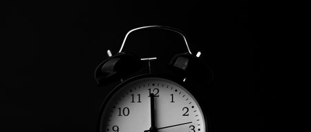 Black alarm clock on black background.の写真素材