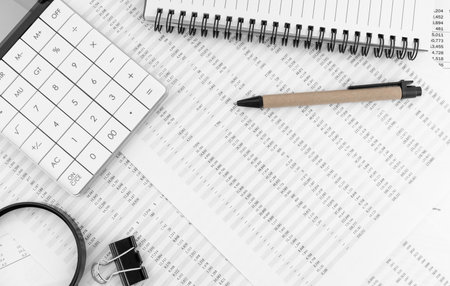 Calculator, magnifying glass, pen, eye glasses lying on financial statement. financial concept. top view.の写真素材