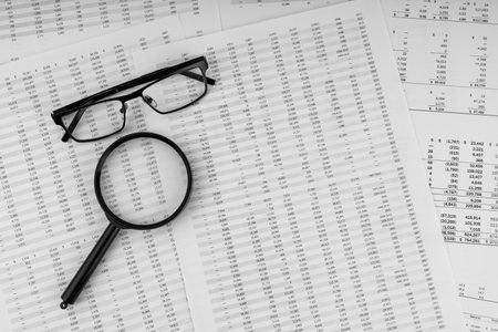 Magnifying glass and eye glasses on financial statement.の写真素材