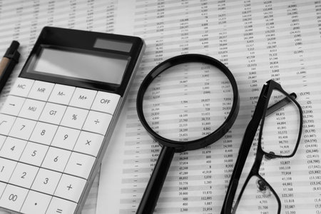 Calculator, magnifying glass, pen, eye glasses on financial statement.の写真素材