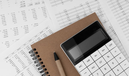 Calculator with notebook on financial statement.