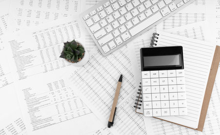 Calculator, keyboard, pen and notebook lying on financial syayement. financial concept.の写真素材