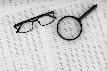 Magnifying glass and eye glasses on financial statement.の写真素材