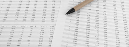 Pen lying on a financial document wide angle view.