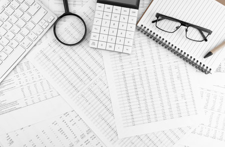 Calculator, keyboard, magnifying glass, pen, eye glasses lying on financial documents . financial and business concept. top view.の写真素材