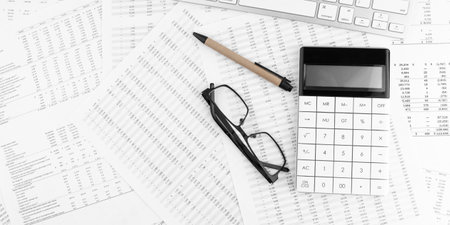 Calculator, keyboard and eyeglasses lying on financial statement . financial concept.の写真素材