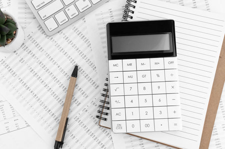 Calculator, keyboard, pen and notebook lying on financial syayement. financial concept.の写真素材