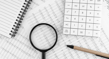 Calculator, magnifying glass, pen lying on financial statement. financial concept. top view.の写真素材
