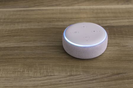 Voice controlled speaker with activated voice recognition, on wood background.の写真素材