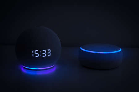 Amazon echo dot, Voice controlled speaker with activated voice recognition, blue light on black background.の写真素材