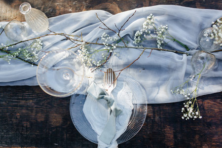 Rustic table setting with flowers and cutlery on wooden background