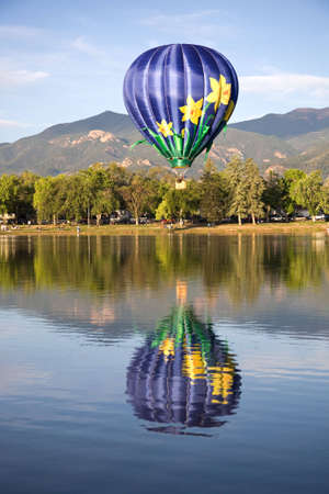 A hot air balloon rises above Prospect Lake during the Colorado Springs Balloon Classic. の写真素材
