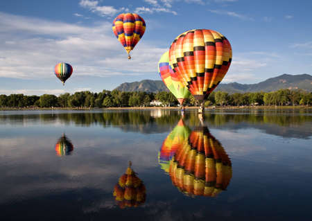 Colorful balloons are reflected in Prospect Lake during Colorado Springs Balloon Classic. の写真素材