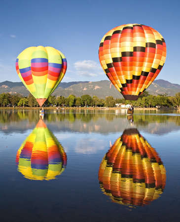 Colorful balloons are reflected in Prospect Lake during Colorado Springs Balloon Classic. の写真素材