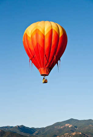 A bright red balloon rises over Coloradoの写真素材