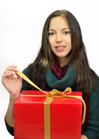 young woman holding a Christmas present in red paper with golderner loopの写真素材