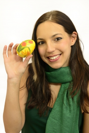 young brunette woman is holding an Easter eggの写真素材
