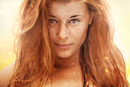 Summer portrait, beautiful freckled young girl with red hairの写真素材