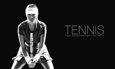 Portrait of beautiful girl tennis player with a racket isolated on black backgroundの写真素材