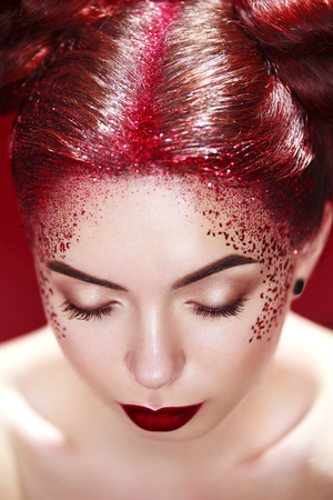 Bright beautiful readhead girl with tinsel and buns hairstyle. Art makup.. Ads for hairdressers and beauty salon.の写真素材