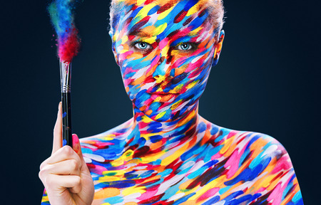 Portrait of the bright beautiful young woman with art make-up on dark backgroundの写真素材