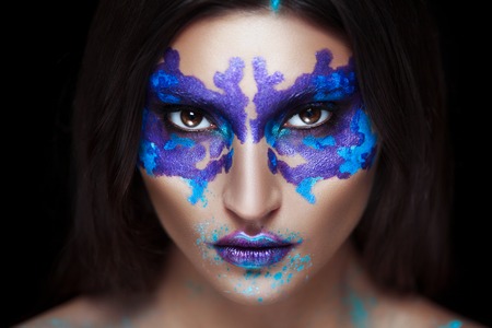 Woman in Halloween makeup with Rorschach test on her face on dark backgroundの写真素材