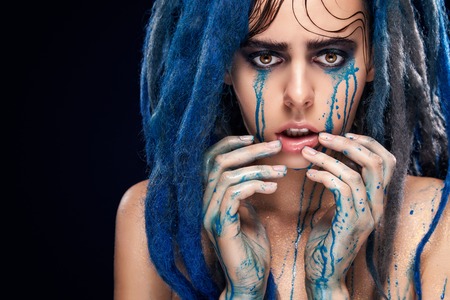 Portrait of a woman with painted face. Creative makeup and bright style.の写真素材