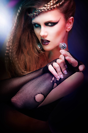 Sexy woman with haircut and art makeup is dancing disco 80 style.の写真素材