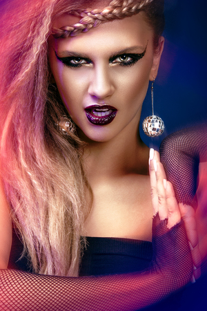 Sexy woman with haircut and art makeup is dancing disco 80 style. Party, dance, night, club.の写真素材
