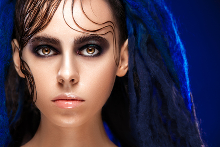 Portrait of a woman with painted face. Creative makeup and bright style.の写真素材