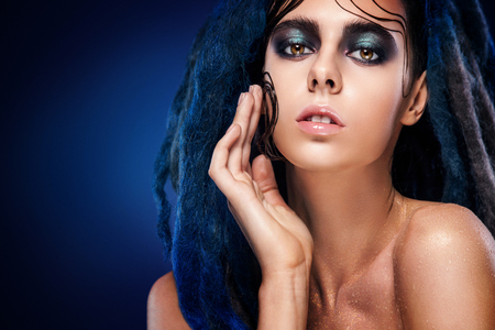 Bodyart model girl portrait with colorful paint make up. Sexy woman bright color makeup. Closeup of vogue style lady face, Art design. Black backgroundの写真素材