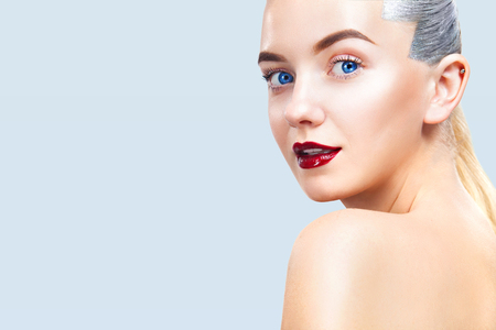 Close-up portrait of sexy blonde girl with makeup. Beautiful model, silver hairstyle. isolated on blue background. For cosmetics ads. Copy Space.の写真素材