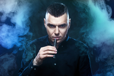 Men vaping and releases a cloud of vapor.の写真素材